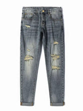 Men’s distressed slim fit blue denim jeans with multiple ripped patches and rolled cuffs in cotton material