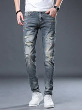 Men’s distressed slim fit dark wash denim jeans with colorful paint splatter accents and ripped knee details