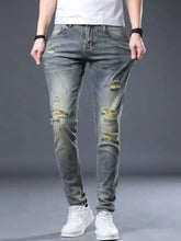 Men’s distressed slim fit gray denim jeans with ripped knees and faded wash in casual style