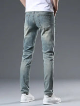 Back side of men’s distressed slim fit jeans in light-wash denim with subtle fading and classic back pockets