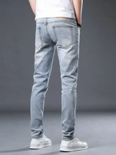 Men’s distressed slim fit jeans in light-wash denim with subtle fading and classic back pockets shown from the back side