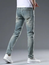 Men’s distressed slim fit jeans in light-wash denim with subtle fading and classic back pockets shown from the back side