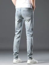 Men’s distressed slim fit jeans in light-wash denim with subtle distressing details and a slim silhouette