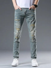 Men’s distressed slim fit jeans in light-wash denim with intentional rips and frayed edges for a casual look