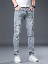 Men’s light-wash denim slim fit jeans with distressed ripped details along thighs and knees for a modern fit look