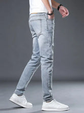 Men’s light-wash slim fit jeans with distressed ripped details on thighs and knees in a slim fit design