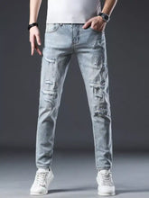 Men’s distressed slim fit jeans in light-wash denim with ripped details and subtle white speckles