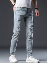 Men’s distressed slim fit jeans in light-wash denim with ripped details and subtle white speckles