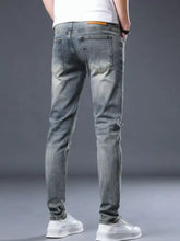 Men’s distressed slim fit jeans in light-wash denim with subtle fading and distressed details for a modern look