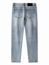 Men’s distressed slim fit jeans in light-wash denim with subtle speckled texture shown from the back side