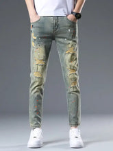 Men’s distressed slim fit olive green denim jeans with paint splatter and ripped detailing on front side