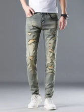 Men’s distressed slim fit jeans in olive green denim with intentional rips and frayed edges