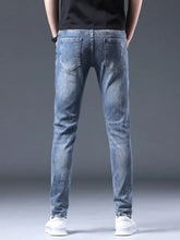 Men’s distressed slim fit ripped jeans in light-wash cotton blend denim with subtle fading and classic back pockets visible from the back