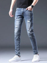 Men’s slim fit light-wash denim jeans with distressed ripped details made from a cotton blend fabric