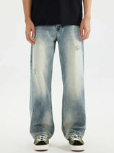 Men’s distressed vintage wash light-wash denim jeans with faded distressing and relaxed straight-leg cut