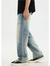 Men’s light-wash denim jeans with distressed vintage wash and relaxed straight-leg loose fit for casual wear