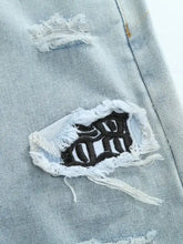 Men’s light-wash distressed wash jeans with black embroidered lettering and frayed edges on distressed patch