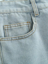 Men’s distressed wash jeans in light-wash denim with subtle faded texture and contrasting tan stitching on pockets