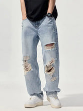 Men’s distressed washed wide leg jeans in light-wash denim with ripped knees and frayed edges