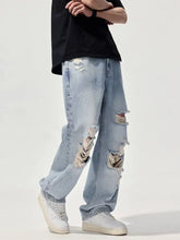 Men’s distressed washed wide leg jeans in light wash denim with frayed ripped details on thighs and knees