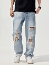 Men’s light-wash denim wide leg jeans with distressed frayed ripped patches on the thighs and knees
