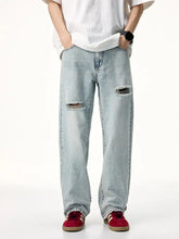 Men’s distressed wide leg jeans in light-wash denim with ripped knees and a relaxed wide leg fit