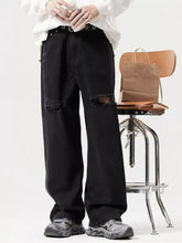 Men’s black distressed denim wide leg jeans with ripped knees and a relaxed fit showcasing wide leg style