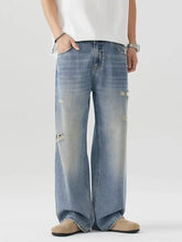 Men’s distressed wide leg jeans in light-wash denim featuring a wide-leg cut and intentional knee distressing