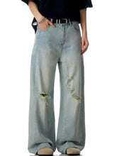 Men’s light-wash denim distressed wide leg jeans featuring frayed holes on the thighs for a stylish look