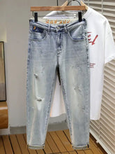 Men’s light-wash denim distressed wide leg jeans with ripped details and a slim-fit cut