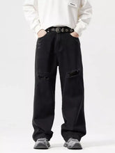 Men’s black distressed denim wide leg jeans with ripped knee patches and a relaxed fit