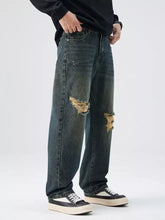 Men’s dark-wash denim distressed wide leg jeans with frayed patches on the knees for a casual look