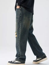 Men’s dark-wash denim distressed wide leg jeans with ripped details on the thigh for a stylish casual look