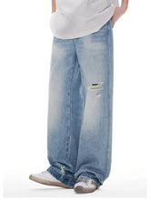 Men’s light-wash denim wide leg jeans with intentional distressing at the knee for a casual look