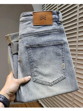 Men’s distressed wide leg jeans in light-wash denim with a faded look and brown leather patch on the back waistband