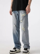 Men’s distressed wide leg jeans in light-wash denim featuring frayed patches and a relaxed fit