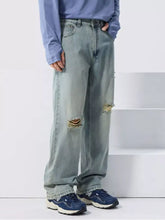 Men’s distressed wide leg light-wash denim jeans with frayed knee holes and a relaxed straight leg cut