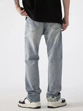 Men’s distressed wide leg jeans in light-wash denim with frayed and ripped details at knees and cuffs