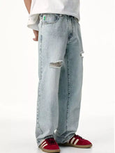 Men’s distressed wide leg light-wash denim jeans with frayed knee holes and a relaxed fit