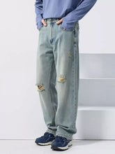 Men’s light-wash wide leg jeans with distressed frayed knee holes and a relaxed fit in denim material