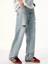 Men’s light-wash denim distressed wide leg jeans with intentional knee rips and a relaxed straight-leg cut