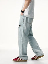 Men’s light-wash denim distressed wide leg jeans with a distressed knee patch and straight-leg cut