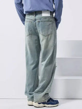 Men’s light-wash denim wide leg jeans with a relaxed fit and subtle fading in a distressed style