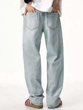 Men’s distressed wide leg jeans in light-wash denim with a relaxed straight-leg cut and classic back pockets shown from back