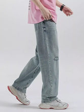 Men’s light-wash denim wide leg jeans with a relaxed straight-leg cut and subtle distressing at the knee