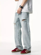 Men’s light-wash distressed wide leg jeans with ripped knees and a relaxed fit in denim material