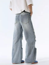 Men’s distressed wide leg jeans in light-wash denim with ripped details along the outer legs