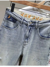 Men’s distressed wide leg jeans in light-wash denim with ripped details and a faded blue color
