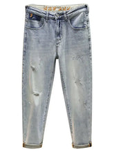Men’s light-wash denim distressed wide leg jeans with ripped details and rolled cuffs in a casual style