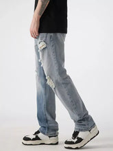 Men’s distressed wide leg jeans in light-wash denim with ripped details on thighs and knees for casual wear